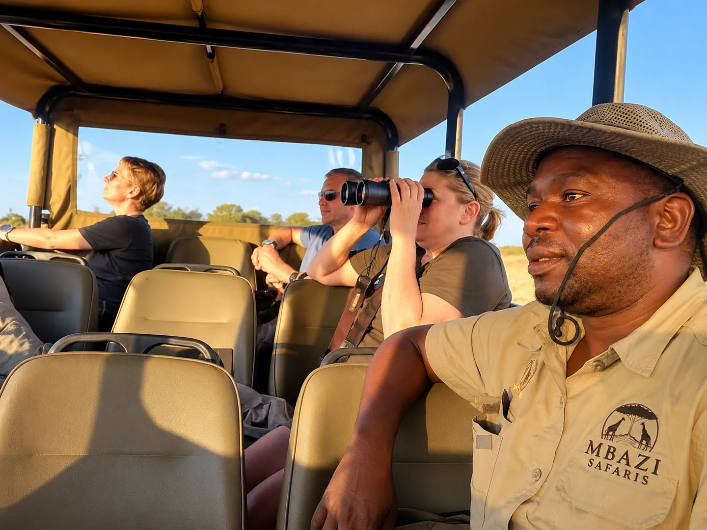 Mbazi Safaris guide and guests watching wildlife with binoculars